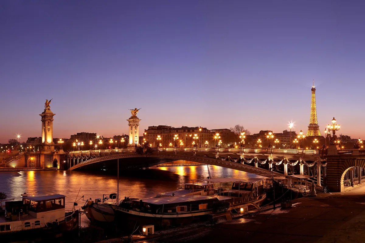The Pont Alexandre III over the Seine at dusk, with the Eiffel Tower behind
