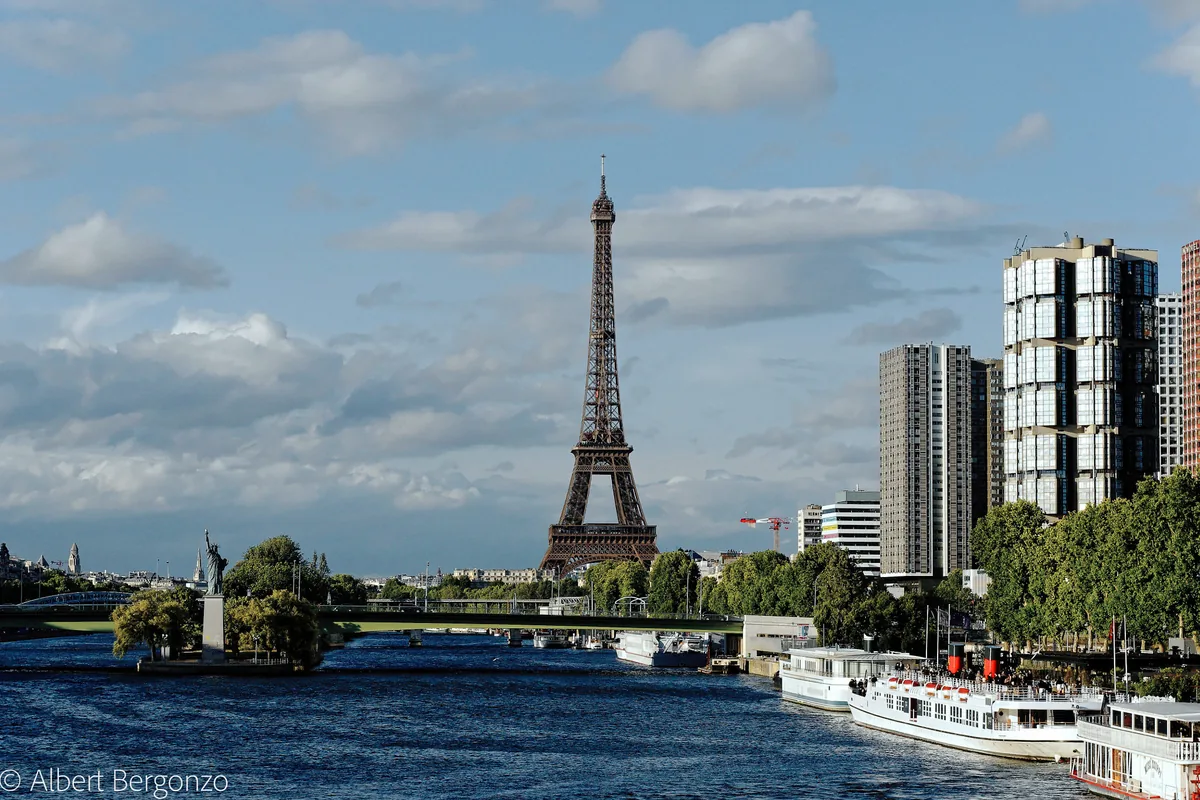 The Eiffel Tower seen from the river Seine, with cruise boats moored
